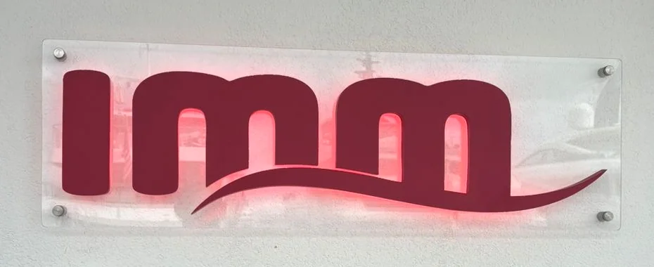 IMM halo-lit logo mounted on an acrylic panel.